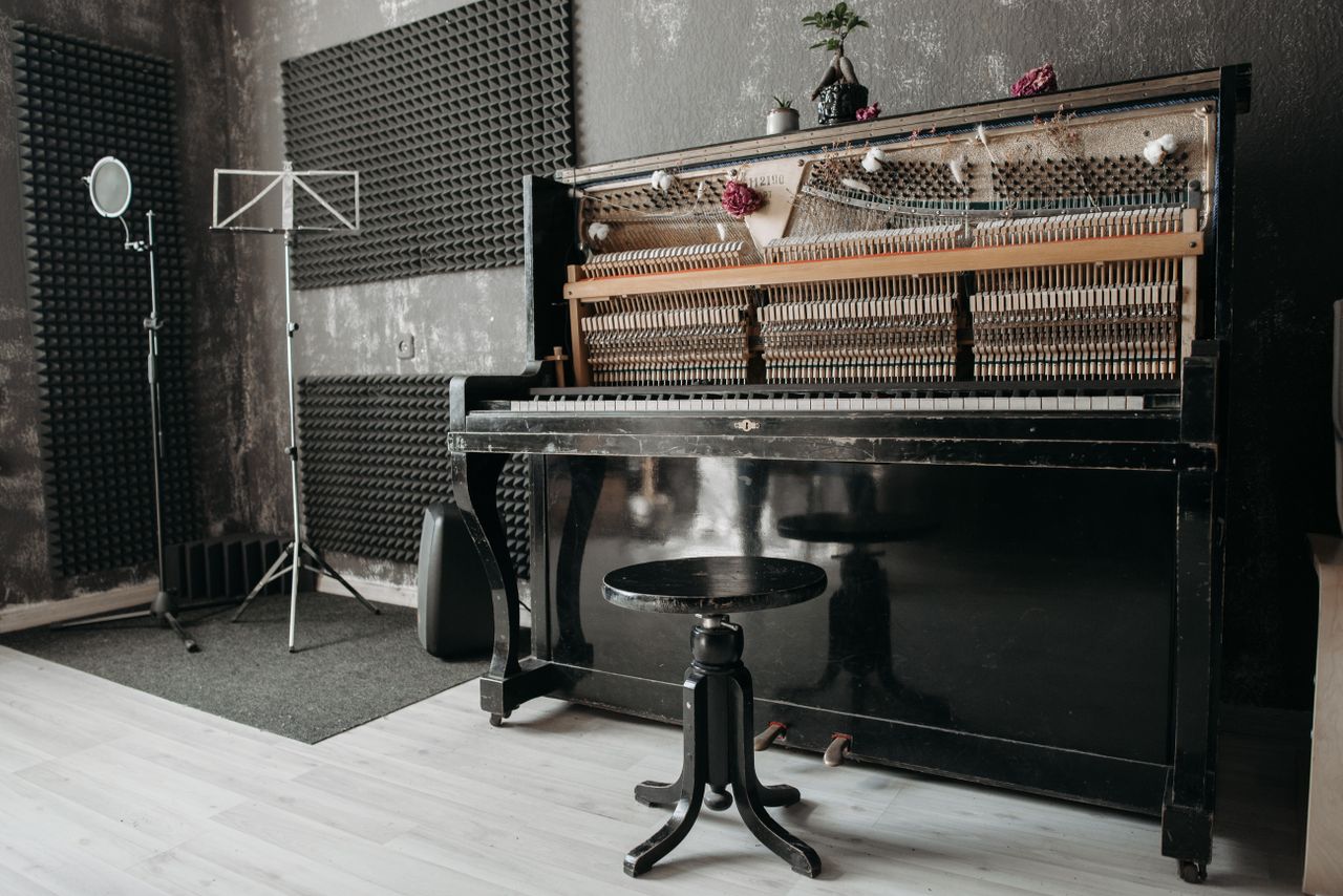 services-03 An open vintage upright piano in a soundproof music studio with recording equipment.